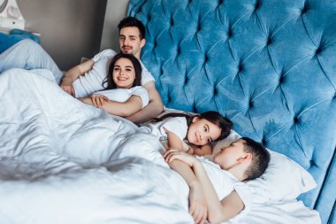 evde yatakta birlikte vakit geçiren aile  