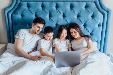 evde yatakta birlikte vakit geçiren aile  