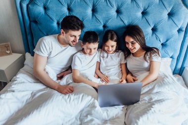 evde yatakta birlikte vakit geçiren aile  