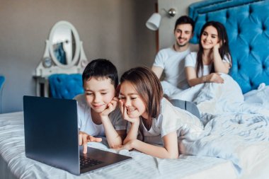 evde yatakta birlikte vakit geçiren aile  