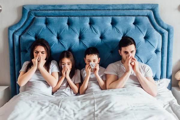 evde yatakta birlikte vakit geçiren aile  