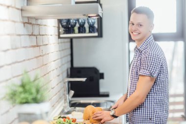 Rahat giyim yakışıklı genç adam kameraya bakarak ve gülümseyerek 