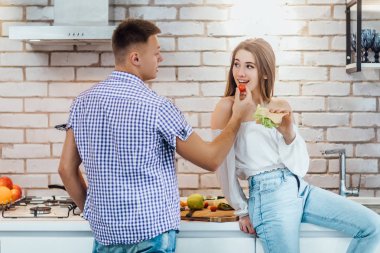 Erkek mutfakta kadın için domates veren, seçici odak