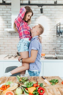 Romantik genç çift mutfakta birlikte yemek ve eğlenmek