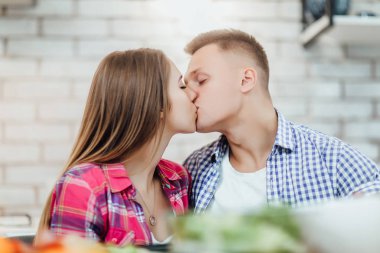 Mutfakta öpüşen genç çift, ön plana odaklan.