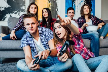 Evde video oyunları oynayan ve eğlenmek arkadaşları ile gülümseyen çift