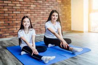 Anne nasıl yoga kelebek evde poz oturup kızı öğretim