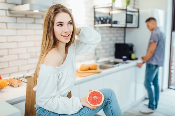 Ung Kvinna Äter Grapefrukt Man Bakgrunden — Stockfoto