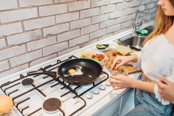 裁剪视图的妇女手准备裂解鸡蛋在煎锅 — 图库照片