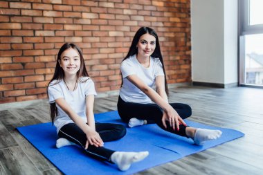 Anne nasıl yoga kelebek evde poz oturup kızı öğretim