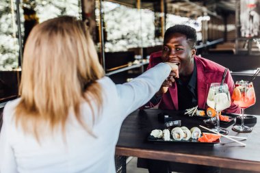 Yakışıklı genç adam ve çekici genç kadın birlikte vakit geçiriyorlar. Kafede romantik çift suşi ile mojito içiyor ve birlikte olmanın tadını çıkarıyor. Adam sevgili kadının elini öpüyor.