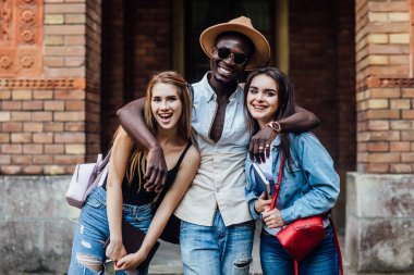 Hugs. Üniversitede dikiliyor. İyi bir ruh hali. Istihbarat. Mutlu öğrenciler birlikte, dışarıda ayakta.