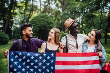 4 Temmuz'u kutlayan Amerikan bayrağı ile doğada dinlenen mutlu dört öğrenci - İstiklal Marşı.