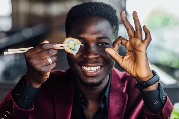 Africano Masculino Segurando Sushi Sob Olhos Tempo Pausa Restaurante — Fotografia de Stock