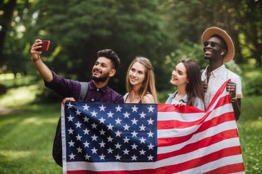 Bir grup genç, 4 Temmuz'u kutlayarak Amerikan bayrağıyla selfie çekti - Bağımsızlık Günü.