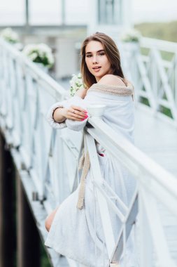 Sabah ev terasında. Genç kadın hafta sonu çay içiyor ve dinleniyor.