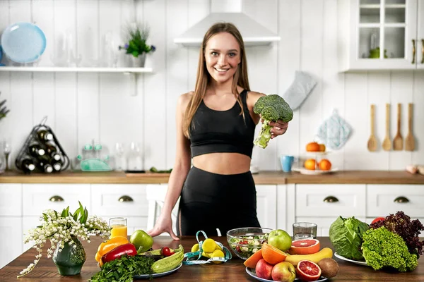 Una Chica Deportiva Sostiene Brócoli Para Cocina Cerca Una Mesa — Foto de Stock