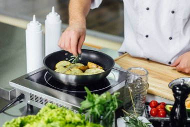 Erkek aşçı taze patates pişiriyor, restoran mutfağında sos. Yemek servisi sırasında yemek pişirmek. İtalyan mutfağı, yaşam tarzı ve sağlıklı gıda konsepti. Eline odaklan. Hpoto 'yu kapat.