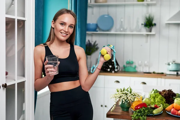 漂亮的胖女人站在厨房的家里 手里拿着一杯水 健康饮食概念 — 图库照片