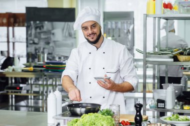 Portre pf şef baharat serpiştirmek ticari mutfak, vejetaryen yemek pişirme.