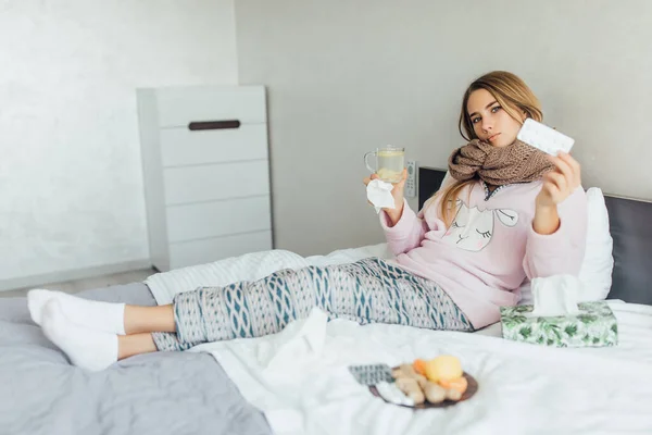 病気の女性が高熱でベッドに横たわっている 風邪と片頭痛の概念 手に枕を保持 — ストック写真