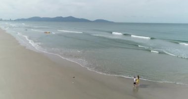 Genç bir çift deniz kıyısı elini kolunu sallaya dönüyor!