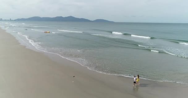 一对年轻夫妇沿着海边漫步 — 图库视频影像