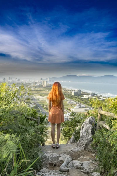 Kızıl saçlı kızla seyahat üstte kalan mermer dağlarında seyahat ediyor ve kavramı Da Nang kenti günbatımı junles, deniz ve dağların Vietnam ile izlerken, seyahat