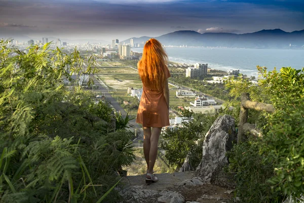 Kızıl saçlı kızla seyahat üstte kalan mermer dağlarında seyahat ediyor ve kavramı Da Nang kenti günbatımı junles, deniz ve dağların Vietnam ile izlerken, seyahat