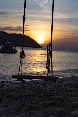 Silhoute gün batımı ve deniz, dağ görünümünde Pho Quoc Adası, sahilde Swing seyahat kavramı