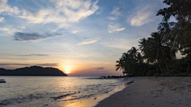 Avuç içi, dağlar ve turuncu gökyüzü güzel manzaralı beach Phu Quoc Adası sae tarafından güzel büyüleyici gün batımı