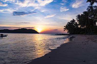 Avuç içi, dağlar ve turuncu gökyüzü güzel manzaralı beach Phu Quoc Adası sae tarafından güzel büyüleyici gün batımı