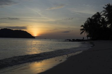 Avuç içi, dağlar ve turuncu gökyüzü güzel manzaralı beach Phu Quoc Adası sae tarafından güzel büyüleyici gün batımı
