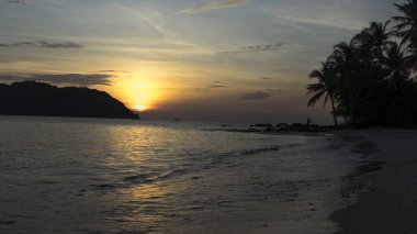 Avuç içi, dağlar ve turuncu gökyüzü güzel manzaralı beach Phu Quoc Adası sae tarafından güzel büyüleyici gün batımı