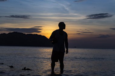 Avuç içi, dağlar ve turuncu gökyüzü güzel manzaralı beach Phu Quoc Adası sae tarafından güzel büyüleyici gün batımı