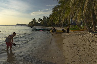 Gün batımı beğenilen Pho quoc Adası güzel manzaralı, insanlar silhouttes sahilde deniz kenarında
