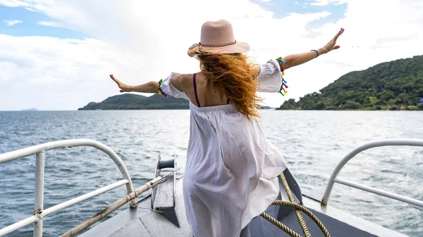Kızıl saçlı kız stayiing bir beyaz bir kruvaziyer gemide elbise ve şapka, teleferik yakınındaki Phu Quoc Adası seyahat