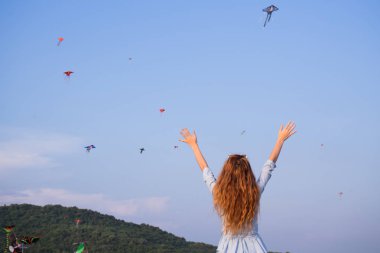 Parkta uçurtma ve dağlar bakış mavi elbise hayran uzun kızıl saçlı kadın turist
