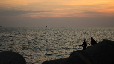 güzel aralığı günbatımı ile Phu Quoc adada denizde balıkçılık adam silueti