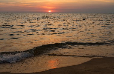 Dalgalı deniz üzerinde renkli gökyüzü ve dramatik bulutlar ile Phu Quoc adası kumlu plajda güzel gün batımı Manzara