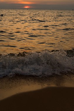 Dalgalı deniz üzerinde renkli gökyüzü ve dramatik bulutlar ile Phu Quoc adası kumlu plajda güzel gün batımı Manzara