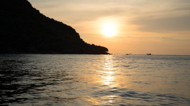 Dalgalı deniz üzerinde renkli gökyüzü ve dramatik bulutlar ile Phu Quoc adası kumlu plajda güzel gün batımı Manzara