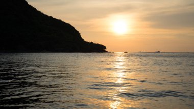 Dalgalı deniz üzerinde renkli gökyüzü ve dramatik bulutlar ile Phu Quoc adası kumlu plajda güzel gün batımı Manzara