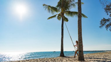 Tatil konsepti. Genç kadın bir plaj salıncak üzerinde salıncak. Phu Quoc plajda mutlu gezgin kadınlar