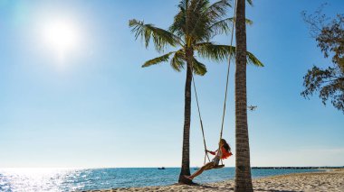 Tatil konsepti. Genç kadın bir plaj salıncak üzerinde salıncak. Phu Quoc plajda mutlu gezgin kadınlar