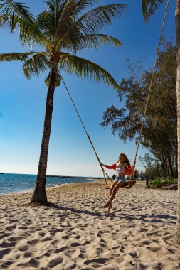 Tatil konsepti. Genç kadın bir plaj salıncak üzerinde salıncak. Phu Quoc plajda mutlu gezgin kadınlar