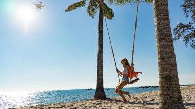 Tatil konsepti. Genç kadın bir plaj salıncak üzerinde salıncak. Phu Quoc plajda mutlu gezgin kadınlar