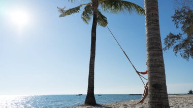 Tatil konsepti. Genç kadın bir plaj salıncak üzerinde salıncak. Phu Quoc plajda mutlu gezgin kadınlar