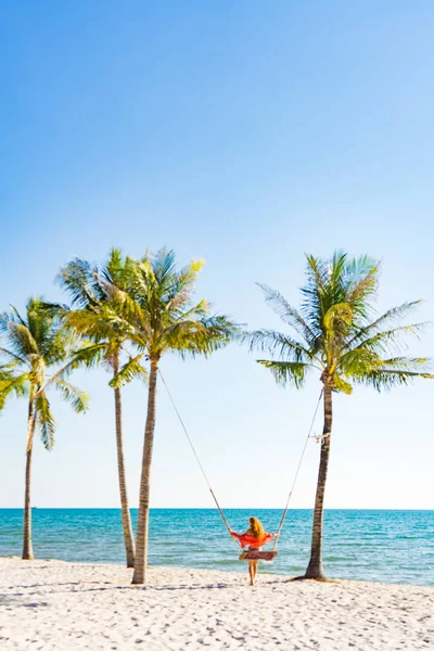 Tatil konsepti. Genç kadın bir plaj salıncak üzerinde salıncak. Phu Quoc plajda mutlu gezgin kadınlar