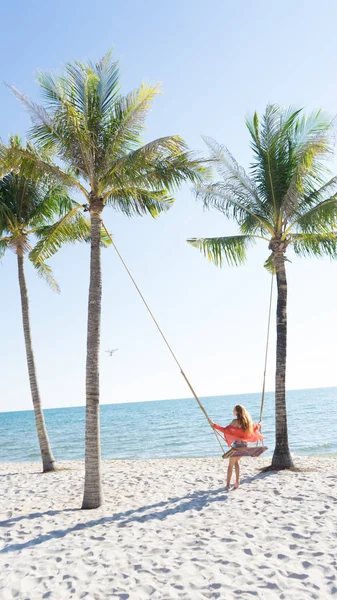 Tatil konsepti. Genç kadın bir plaj salıncak üzerinde salıncak. Phu Quoc plajda mutlu gezgin kadınlar